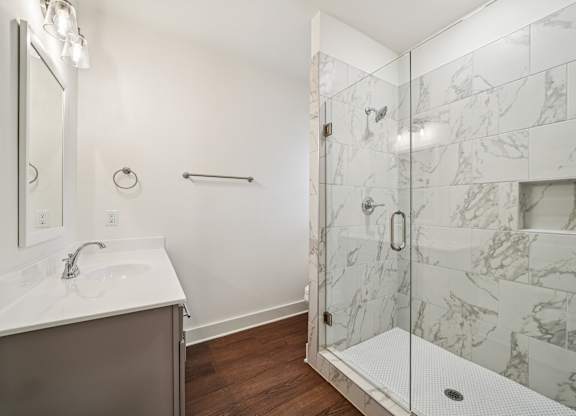 Luxury bathroom with glass door shower and marble tile at Turnberry Park Apartments