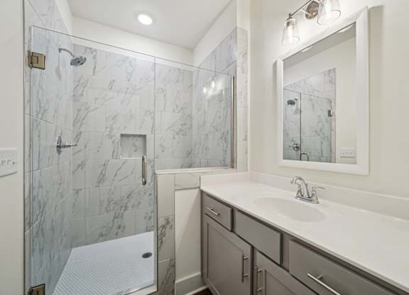 Luxury bathroom with glass door shower and marble tile at Turnberry Park Apartments