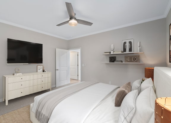 a bedroom with a large bed and a tv at The Cottages at Foley Farms apartments in Foley, AL