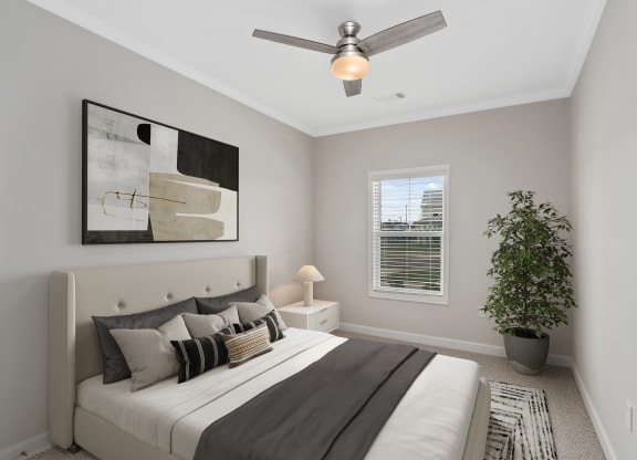 a bedroom with a large bed and a ceiling fan at The Cottages at Foley Farms apartments in Foley, AL
