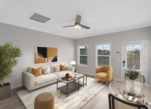 a living room with a couch and a coffee table and a ceiling fan at The Cottages at Foley Farms apartments in Foley, AL