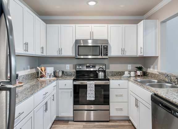 a kitchen with white cabinets and granite countertops