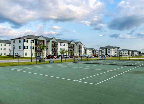 a tennis court at the whispering winds apartments in pearland, tx