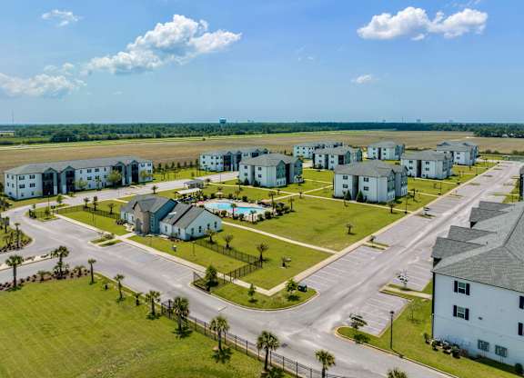 an aerial view of a housing complex with a runway in the background