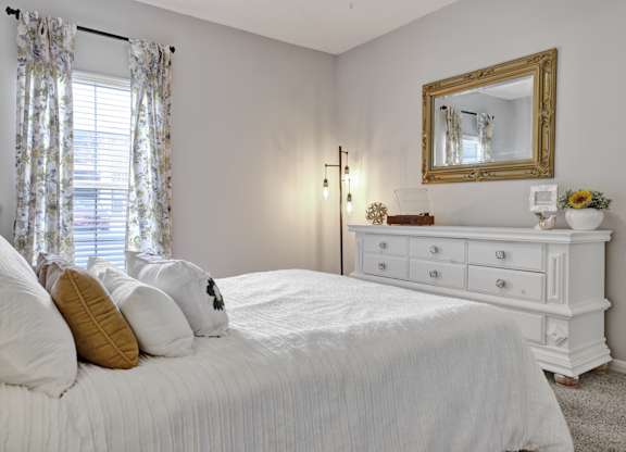 Bedroom with plush carpet and window at Village at Caldwell Mill Apartments in Birmingham, AL