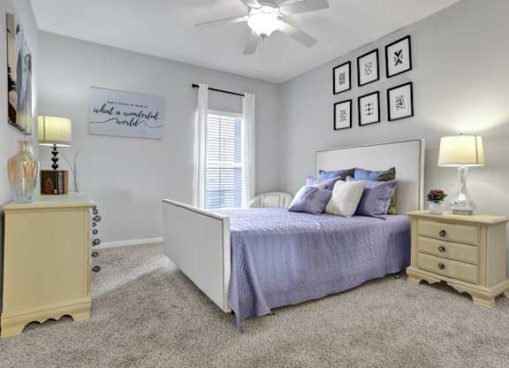 Bedroom with plush carpet and window at Village at Caldwell Mill Apartments in Birmingham, AL