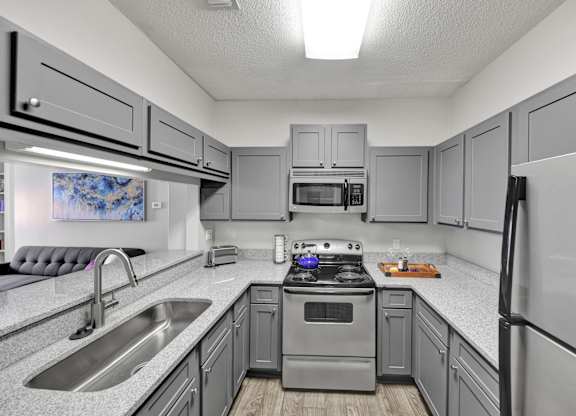A remodeled kitchen with stainless steel appliances at Village at Caldwell Apartments in Birmingham, AL
