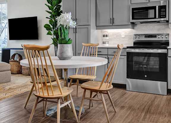 A modern kitchen with plank flooring, stainless steel appliances and custom cabinetry at West Row Lofts and Townhomes in Birmingham, AL