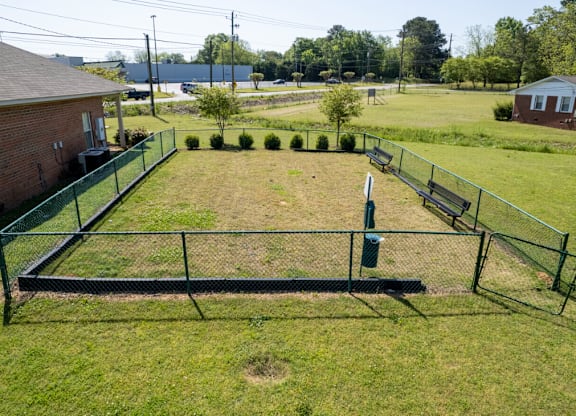 A black metal fence encloses a grassy yard.