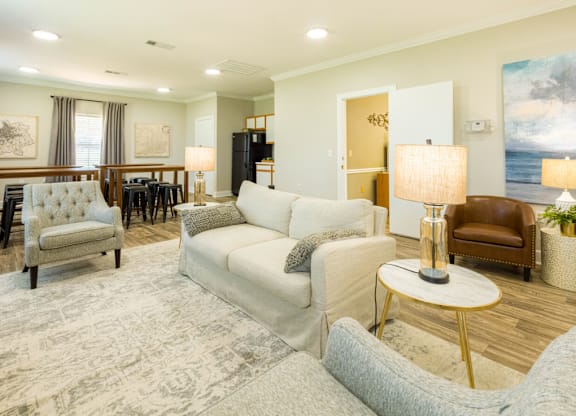 A well-lit living room with a grey sofa and a wooden floor.