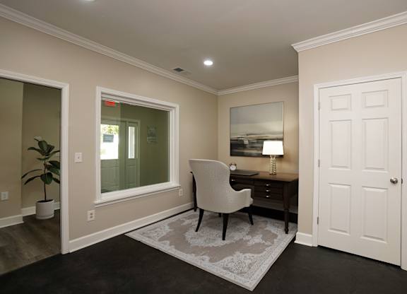 A room with a desk and chair in it.