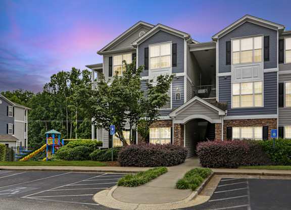 A large apartment complex with a playground in the front.