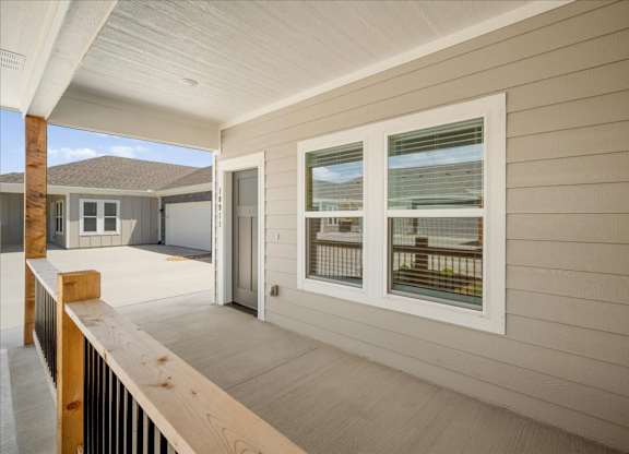 A balcony with a sliding door and a window overlooking a beach.