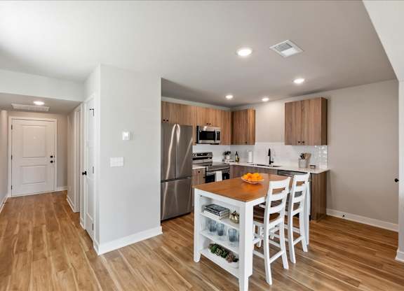 A kitchen with a table and chairs in the middle of the room.