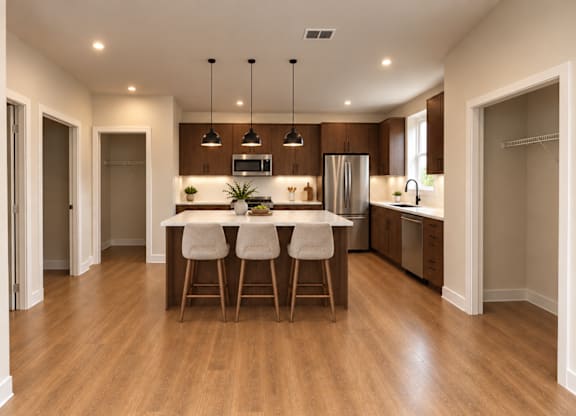 A modern kitchen with wooden floors and a central island.