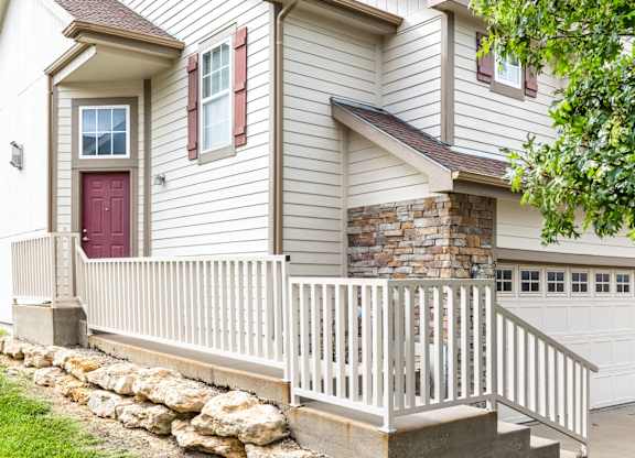 A house with a red door and a stone wall.