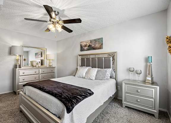 A bedroom with a bed, nightstand, and dresser.