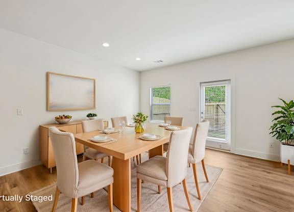 A dining room with a wooden table and chairs.