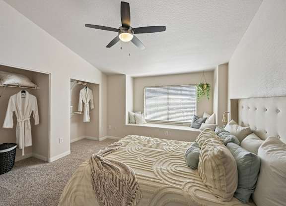 A bedroom with a large bed and a ceiling fan.