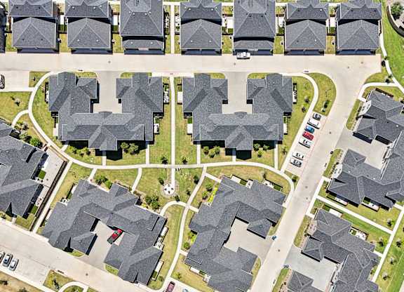 A bird's eye view of a neighborhood with houses and streets.