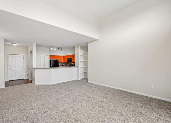 A spacious living room with a television and built-in shelves.