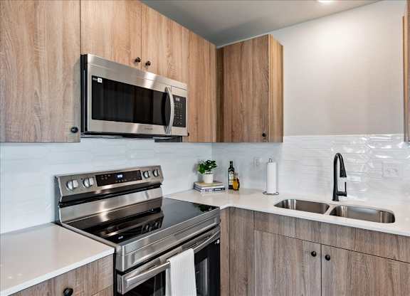 A modern kitchen with wooden cabinets and stainless steel appliances.