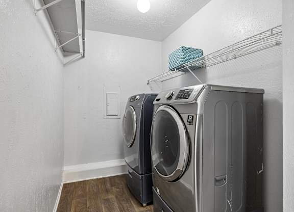 A laundry room with two front loading washing machines.
