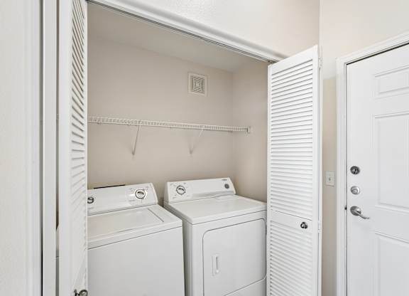 A white laundry room with a washer and dryer.