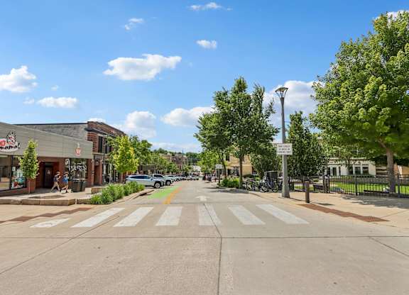 A street view with a crosswalk and a sign on the right.