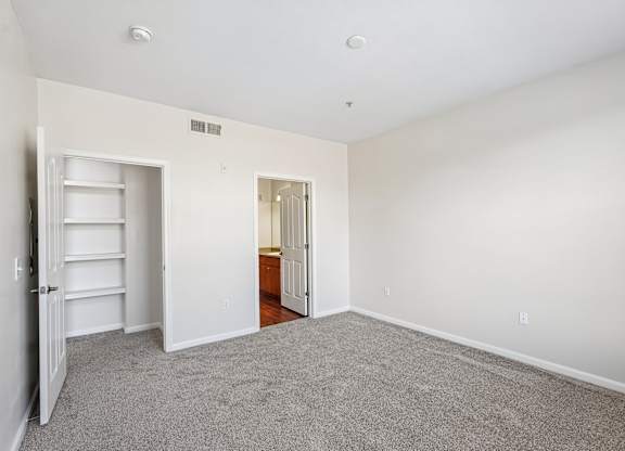 A room with a white door and a white shelf.