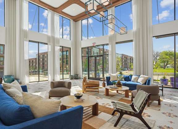 A large, modern living room with a high ceiling and large windows.