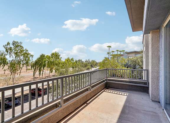A balcony with a metal railing and a concrete pillar.