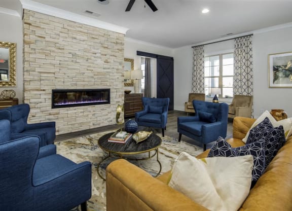 a living room with blue chairs and a fireplace