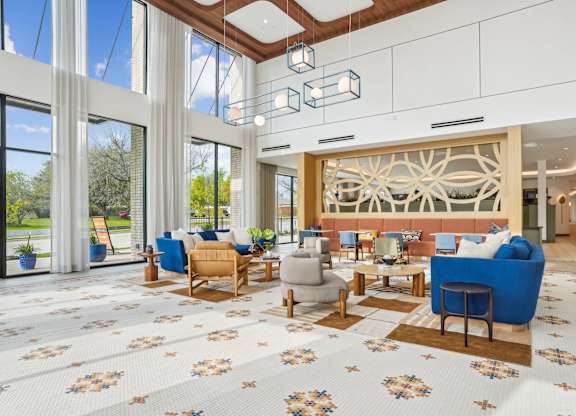 A spacious living room with a large window and a wooden panel wall.