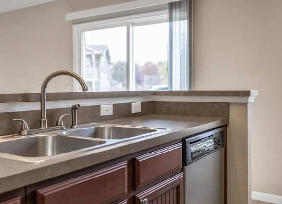 A kitchen with a double sink and a window.