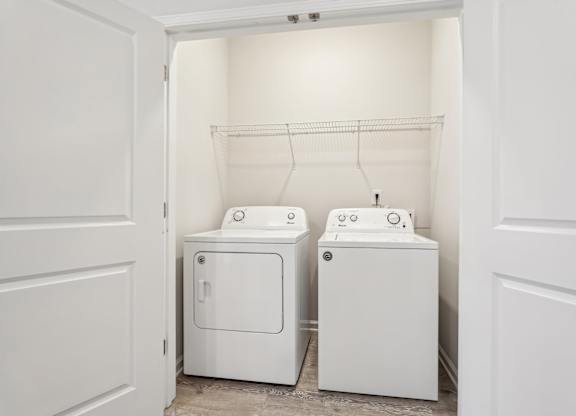 A white laundry room with a washer and dryer.