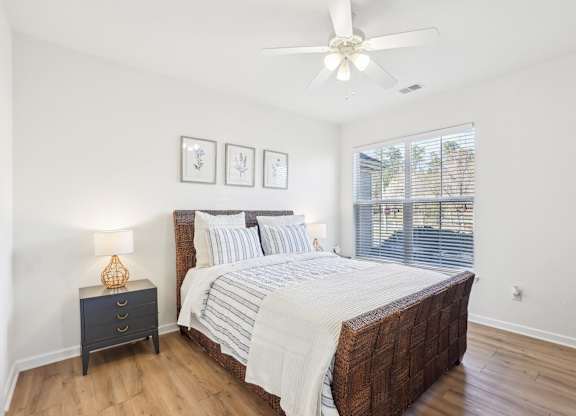 A bedroom with a large bed and a ceiling fan.