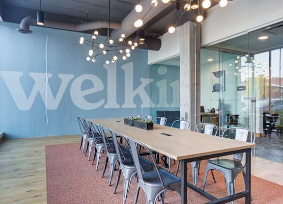 A conference room with a long table and chairs with a sign that says Welki.