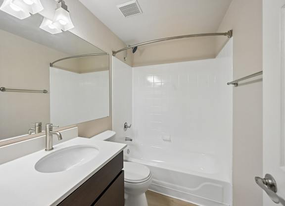A white sink is on a countertop in a bathroom.