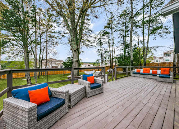 a large deck with furniture on it and trees