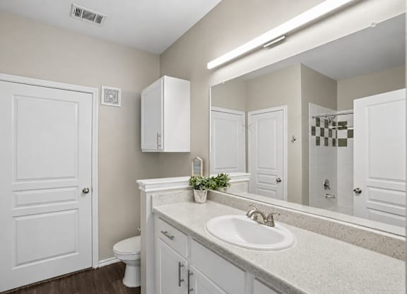 A bathroom with a white sink and a white toilet.