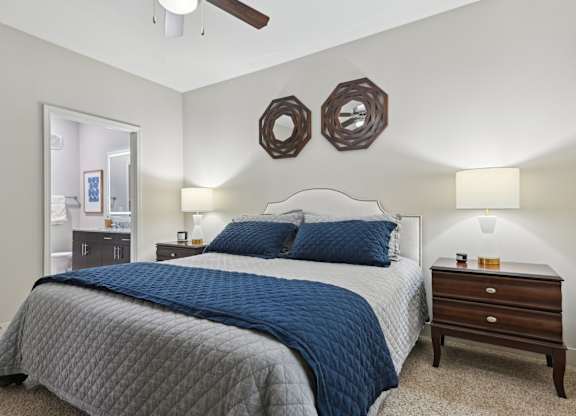 A bedroom with a bed, dresser, and mirror.