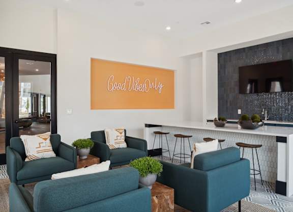 A living room with a green couch and a sign that says