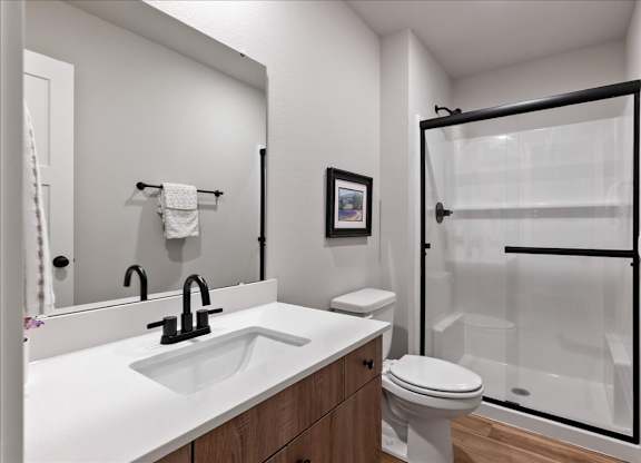 A white bathroom with a black sink and a white toilet.