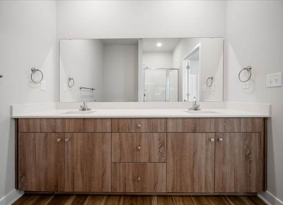 A bathroom with a wooden vanity and a large mirror.
