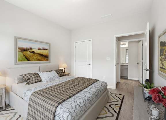 A bedroom with a large bed and a painting on the wall.