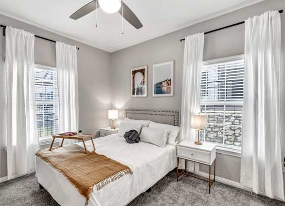 a bedroom with a bed and two windows