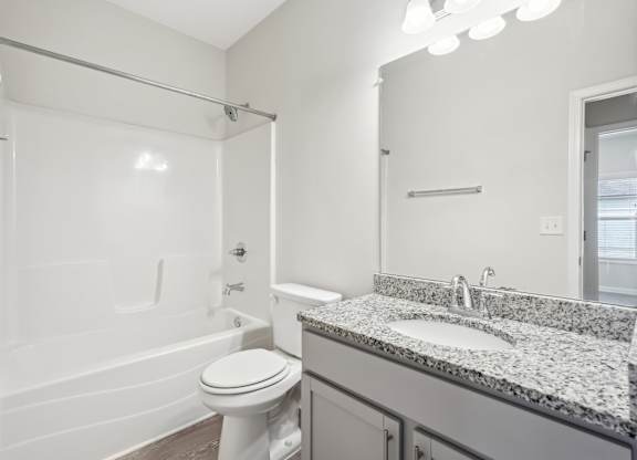 A white bathroom with a toilet, sink, and shower.