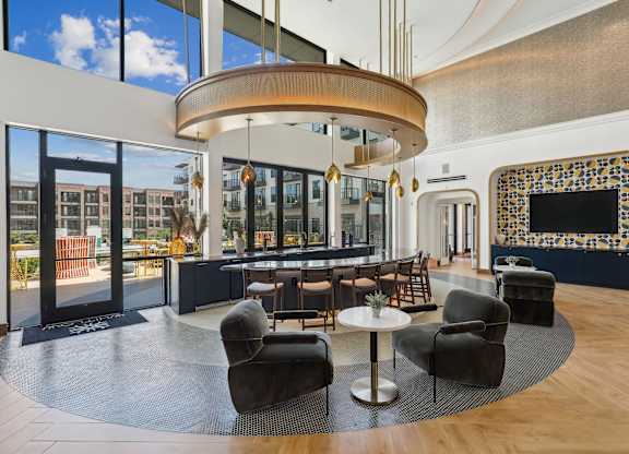 A modern living room with a large circular light fixture and a fireplace with a mosaic tile surround.
