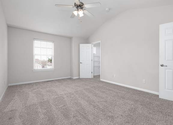 A room with a ceiling fan and carpeted floor.
